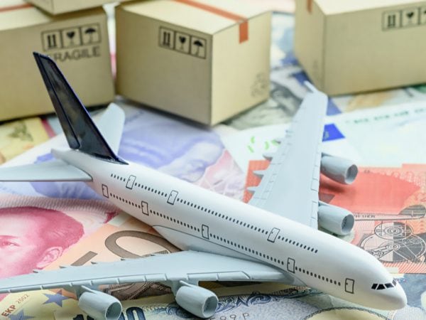 An Airplane On Top Of Money With Boxes In The Background Indicating Cross Border Shipping - Cedric Millar Tech Enabled Supply Chain Company Canada